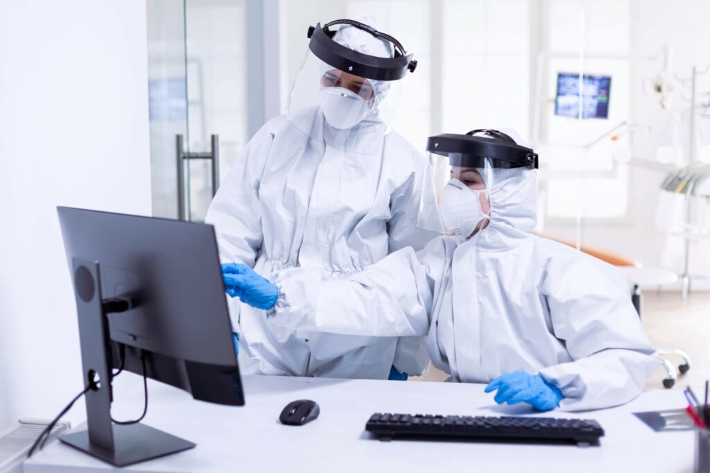 doctor-and-nurse-in-ppe-suit-looking-at-monitor-297GGCS-scaled