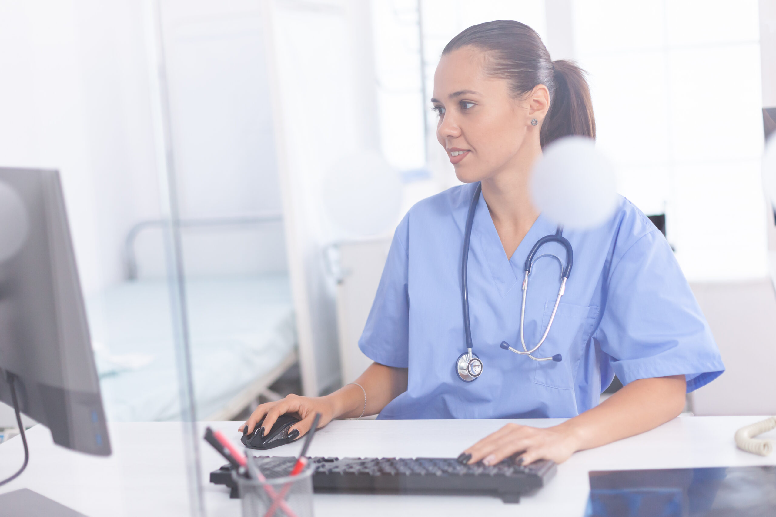 How Often Should You Replace Your Scrubs? 1 Medical practitioner using computer